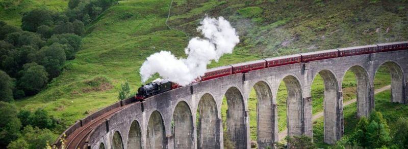 Vista del viaducto de Glenfinnan y el Tren de Vapor de Jacobite o Expreso de Hogwarts en Escocia